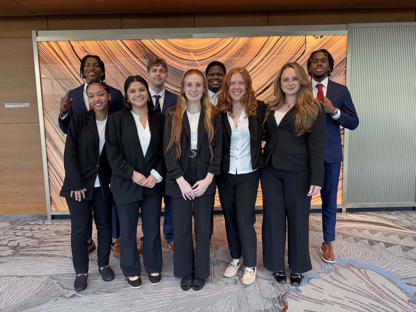 The full Next Gen Exposure Inc team in business attire at a company event